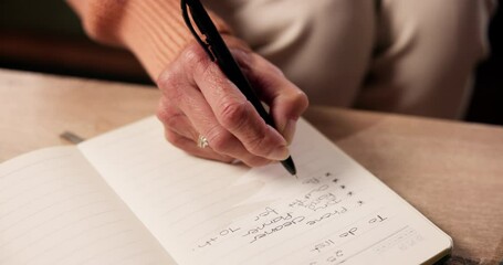 Hand, to do list and writing with person in living room of home for planning or reminder of tasks. Diary, journal or notebook with senior woman in apartment for agenda, checklist or event schedule