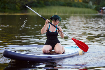 Young Woman on Paddleboard Practicing Paddling in Peaceful Lake