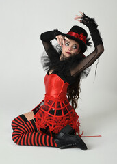 Burlesque circus performer, fantasy female model in halloween jester clown costume with top hat,...