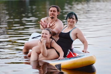 Obraz premium Family Having Fun on a Paddleboard in a Scenic Lake Setting
