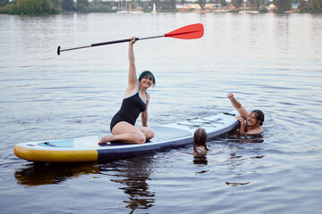 Family Enjoying Paddleboarding and Swimming Together on a Serene Lake