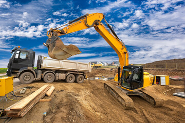 Ein Bagger arbeitet auf einer Baustelle und belädt einen LKW mit Erde aus einer Baugrube für...