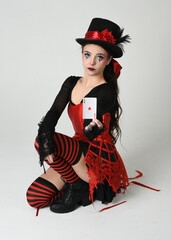 Burlesque circus performer, fantasy female model in halloween clown costume with top hat, red...