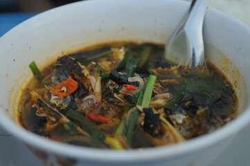 A close up photo of Thai spicy fish soup on a bowl
