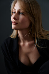 Elegant portrait of woman gazing thoughtfully, exuding confidence and style. The dark backdrop and...