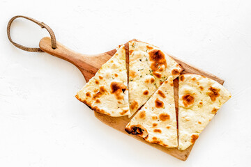 Make focaccia. Traditional italian bread on cutting board on white table top-down copy space