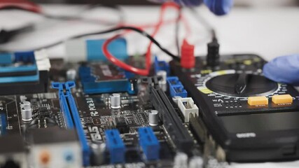 Dnipro. Ukraine, 17 june 2025: Testing motherboard with probes and multimeter, Close-up of technician using probes on computer motherboard with red multimeter during electronic diagnostics