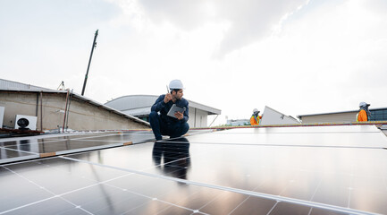 Engineer service check installation solar cell on the roof of factory. Silhouette technician inspection and repair solar cell on the roof of factory. Technology solar energy renewable.
