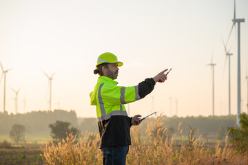 Engineer wearing uniform inspection and survey work in wind turbine farms rotation to generate...