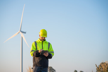 Engineer wearing uniform inspection and survey work in wind turbine farms rotation to generate...
