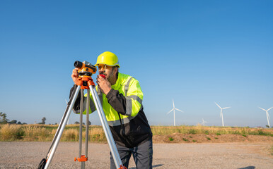 Engineer wearing uniform inspection and survey work in wind turbine farms rotation to generate...