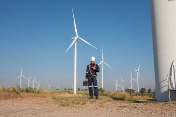 Engineer wearing uniform inspection and survey work in wind turbine farms rotation to generate...