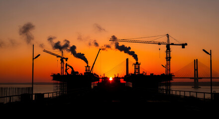 Vibrant Sunset Behind Industrial Scenery With Cranes And Ongoing Construction