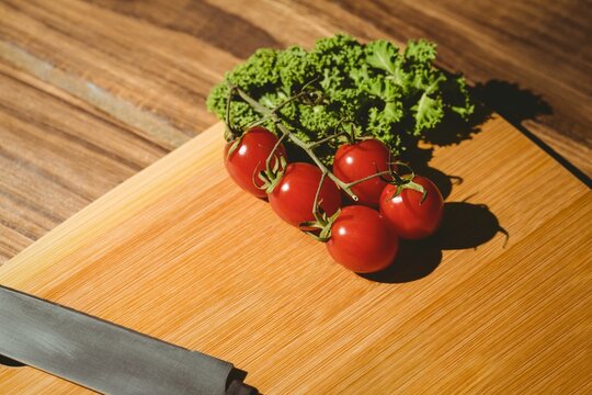 Fototapeta Tomatoes and parsley on chopping board