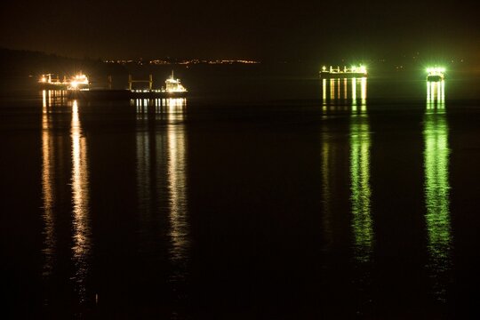 Illuminated boats in sea night
