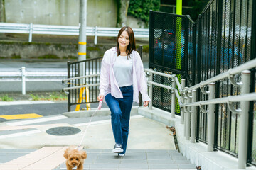 ペットと散歩する若い女性