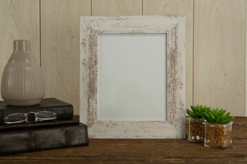 Photo frame, book and plant, on table