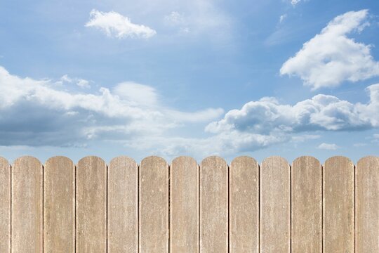 Fototapeta Flat design vertical wooden slat fence is stretching under bright blue sky dotted with clouds