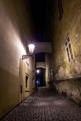 Flat design showing cobblestone alley glowing by lanterns and arches framing windows forming tunnel