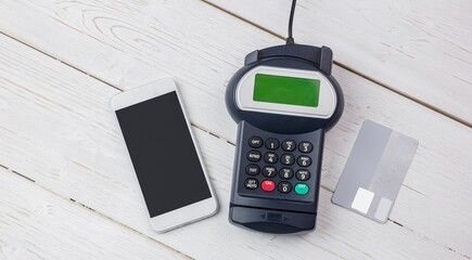 Payment devices are showing on white table, flat design featuring smartphone, reader, credit card