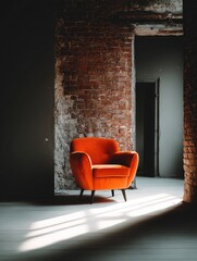 Sunlit burnt-orange armchair in a rustic, unfinished interior with exposed brick wall and doorway