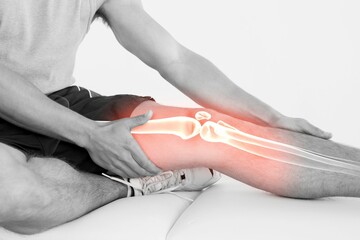 Man with knee pain holding leg