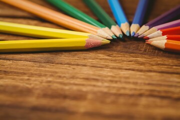 Color pencils arranged on wooden table