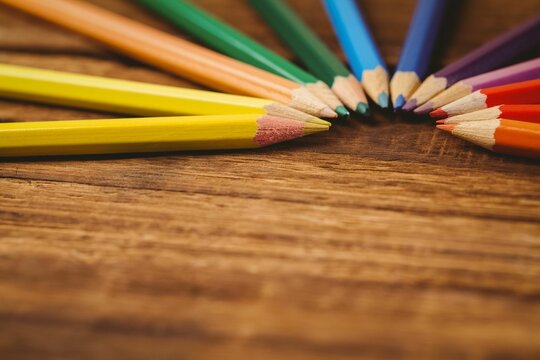 Color pencils arranged on wooden table