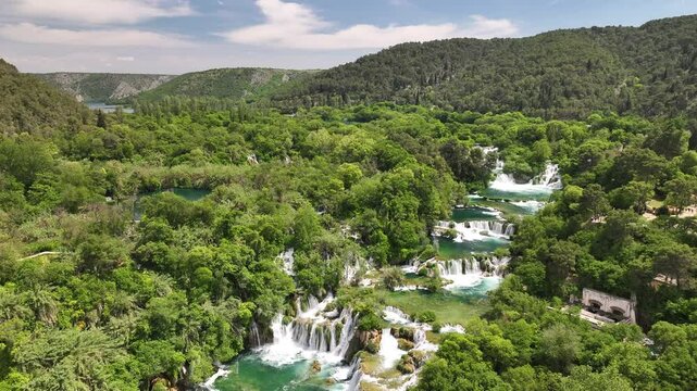 Drone video of Skradinski Buk in Krka National Park, Croatia. It captures the river winding through lush hills, framed by forests and natural terrain.