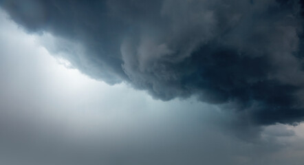 Heavy clouds in shades of gray gather ominously in the sky, signaling an approaching storm.