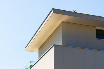 Modern white apartment building with clean lines, glass railings, and minimalist aesthetics