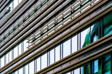 Modern facade with horizontal metal fins and reflective glass windows forming a layered diagonal...