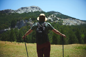 Man Hiking in Rugged Mountain Terrain on a Sunny Day