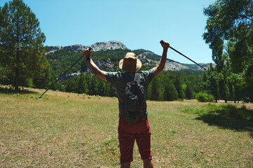 Adventurer Stands Triumphant After Hike Through Scenic Mountain Terrain