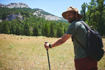 Bearded Adventurer Hiking in Scenic Mountain Landscape on a Hot Summer Day