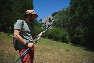 Man Preparing Hiking Gear in Serene Mountain Landscape