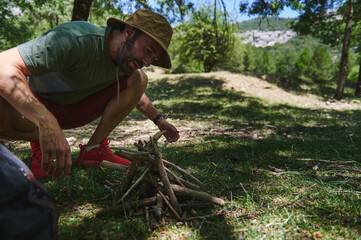 Man Preparing Firewood for a Campfire in a Forested Mountain Area
