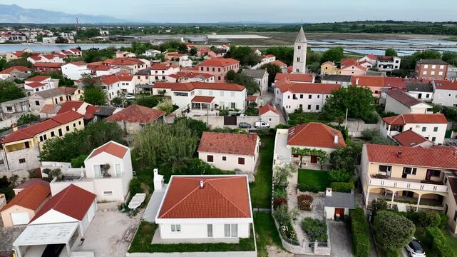 Historic coastal town Nin captured by drone in spring. Old town Nin with stone houses and Adriatic backdrop filmed from above, showing heritage and coastal charm in springtime Croatia