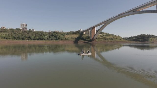 Aerial drone footage of the Friendship Bridge connecting Brazil and Paraguay over the Paran&aacute; River. The scene captures the international border near Foz do Igua&ccedil;u and Ciudad del Este, showing traffic 