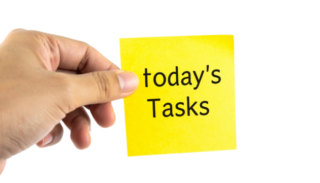 A hand holds a yellow sticky note with the words "Today's Tasks" written on it, suggesting a focus on productivity, goals, and reminders