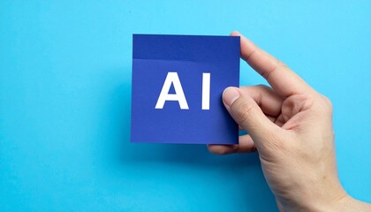 Hand holding a blue note with the letters AI written on it against a blue background.  