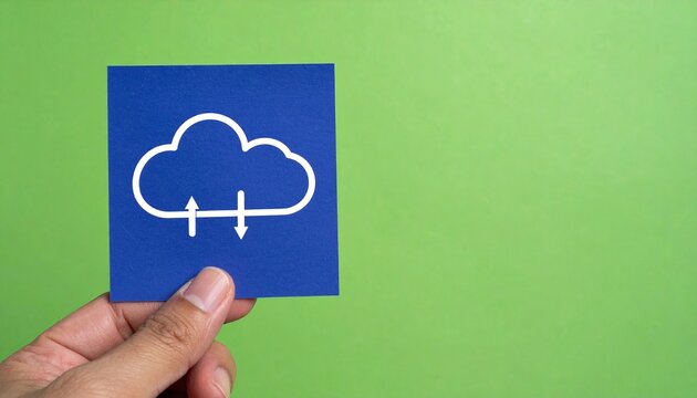 A hand holding a paper cutout of cloud icon against green background, representing cloud storage and computing