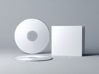 Two blank white CDs and a square case rest on a light gray surface, one disc upright and the other lying down, showcasing a clean, minimalist design