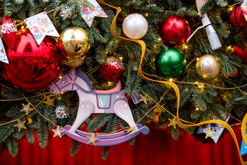 Close-up. Beautiful red horse on a Christmas tree. Beautiful Christmas background. Concept of...