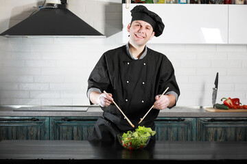 Man cook preparing food at the kitchen of vegetables