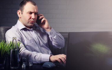 man at table and working on laptop