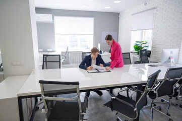 Caucasian woman giving instructions to subordinate. 