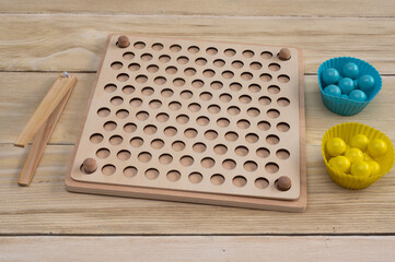 Wooden sorting board - games with colorful balls. The game is based on the Montessori system.