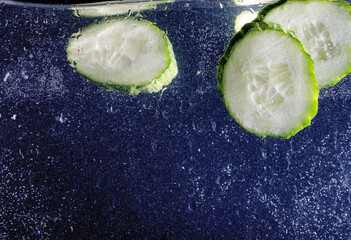 Water drops on ripe cucumber. Fresh vegetables background with copy space for your text. Vegan...