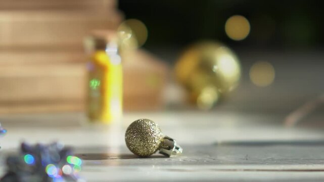 Holiday decor. Packing holiday gifts. Gift boxes, silver bow and Christmas gold balls against the backdrop of the Christmas tree and golden bokeh